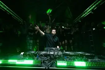 DJ bajo una catedral de luz verde